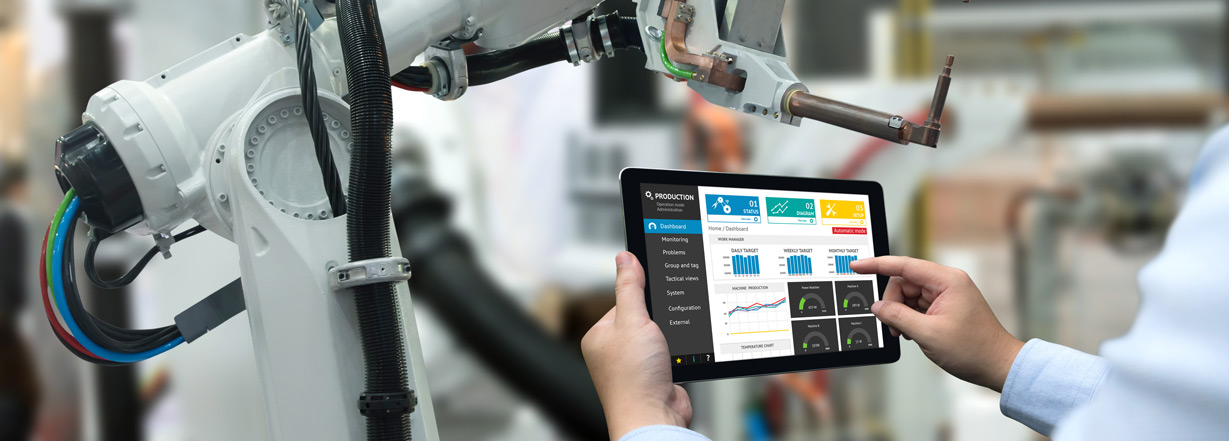  Image of an industrial engineer recording productivity reports of machines in factory with tablet computer in hands.